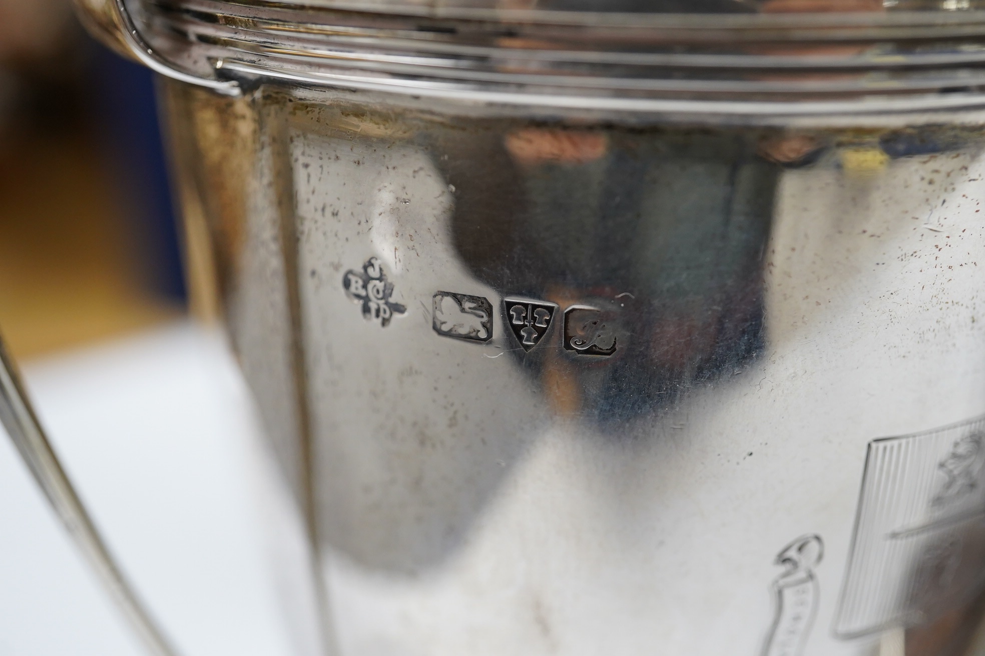 A George V silver two handled presentation trophy cup, 21.8cm, a modern silver wine coaster, a modern mounted silver photograph frame and a George V silver mounted photograph frame. Condition - poor to fair